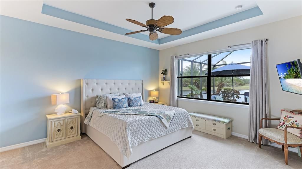 Primary Bedroom with tray ceiling and ceiling fan.