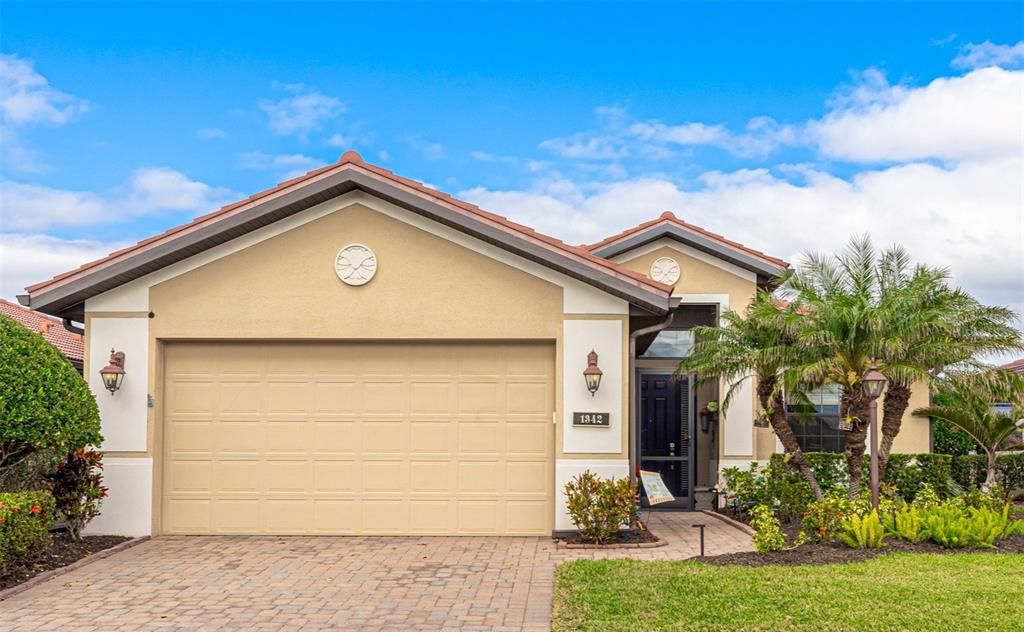 Beautiful paver driveway and walkway with new tropical landscaping leading to an enclosed front porch for that warm ocean breeze.