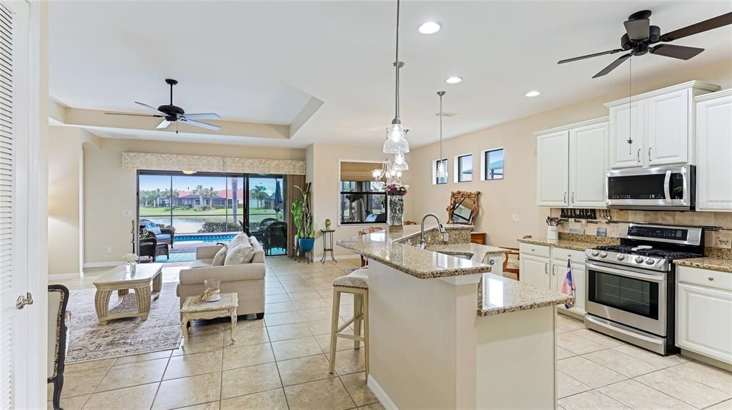 Open Concept Kitchen/Living Room Dining Room with ceiling fans, tray ceilings and abundant light from side windows and sliders out to the Lanai. Florida living!