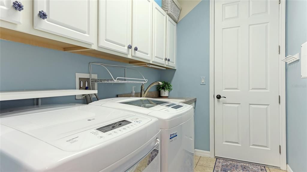 Laundry Room with abundant upper cabinet storage, storage closet and access door to the garage.