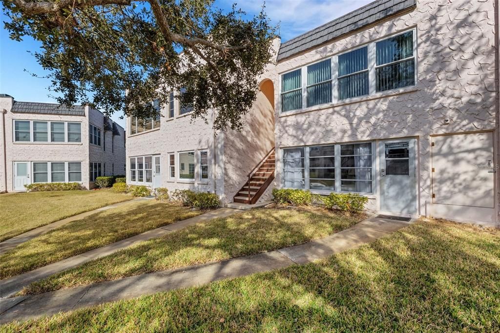 Rear of Unit with Pedestrian Door and Walkway to Pool and Clubhouse.