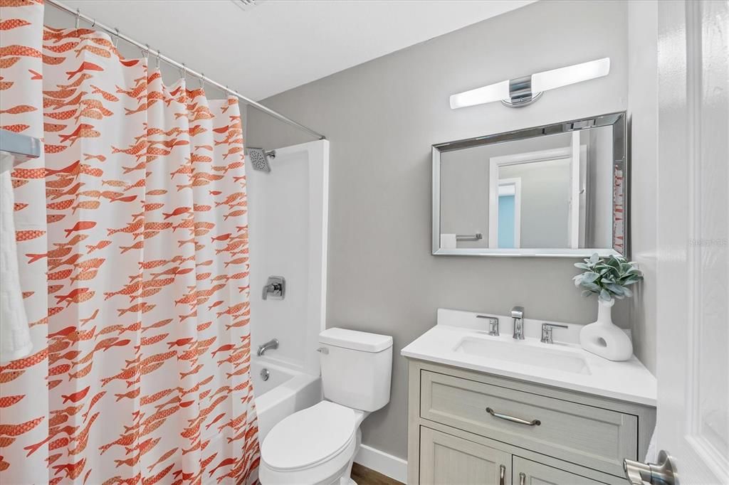 2nd bathroom features a tub / shower insert, new cabinetry and lighting