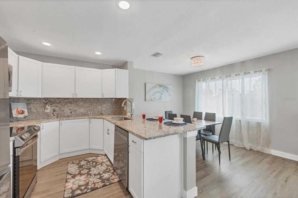 Dining area off the kitchen with impact window and drapes