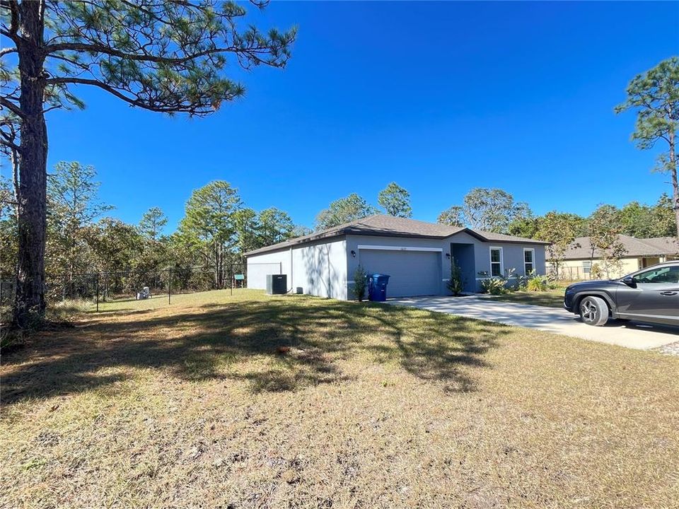 Side view of this newer beautiful 4/2 home on an acre with a fenced backyard.