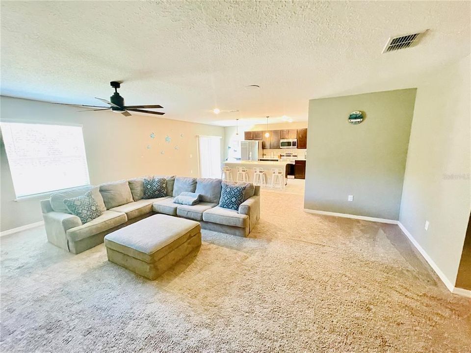 Impressive size TV Room with ceiling fan, view of backyard and plenty of space to host a gathering.