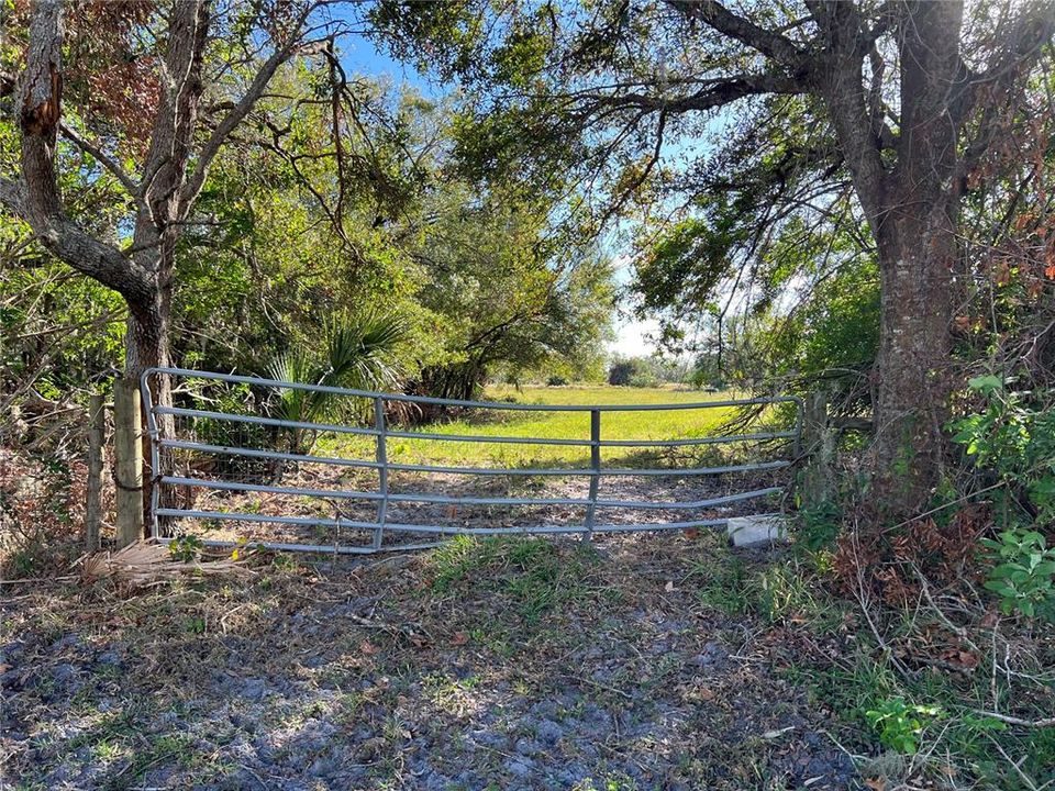 Access is Behind Stop Sign in Grassy Area to Gate