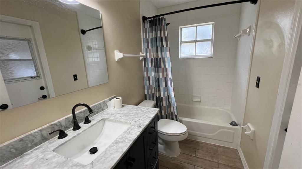 Updated guest bathroom with door leading to screen porch