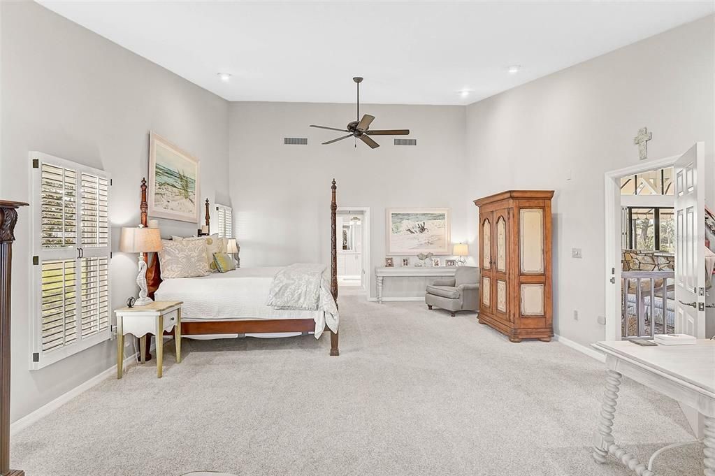 Primary Bedroom, peeking into the recently remodeled Primary Bath, with a door to the pool area