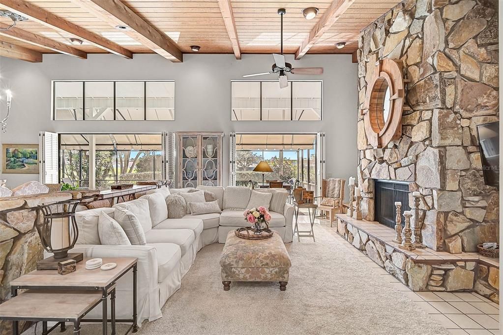 Another view of the Family Room, with a beautiful stone fireplace, looking out to the pool.