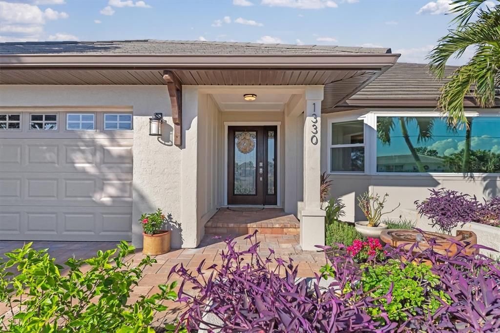 Serene fountain and quaint garden area welcome you home.