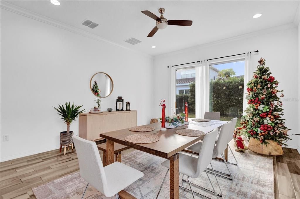 This charming dining room is filled with natural light, featuring large windows with a view of the backyard making it perfect for intimate meals or family gatherings.