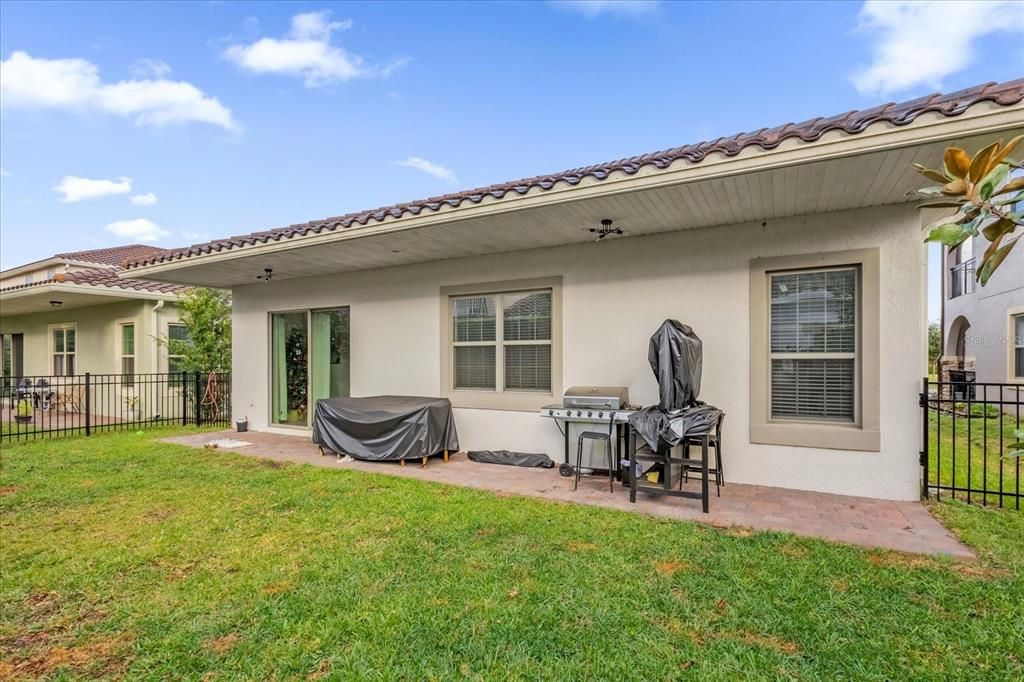 Spacious backyard featuring a covered patio, paved flooring and outdoor lights perfect for outdoor entertaining or relaxing. The fenced yard offers security, ideal for families or pets to enjoy.