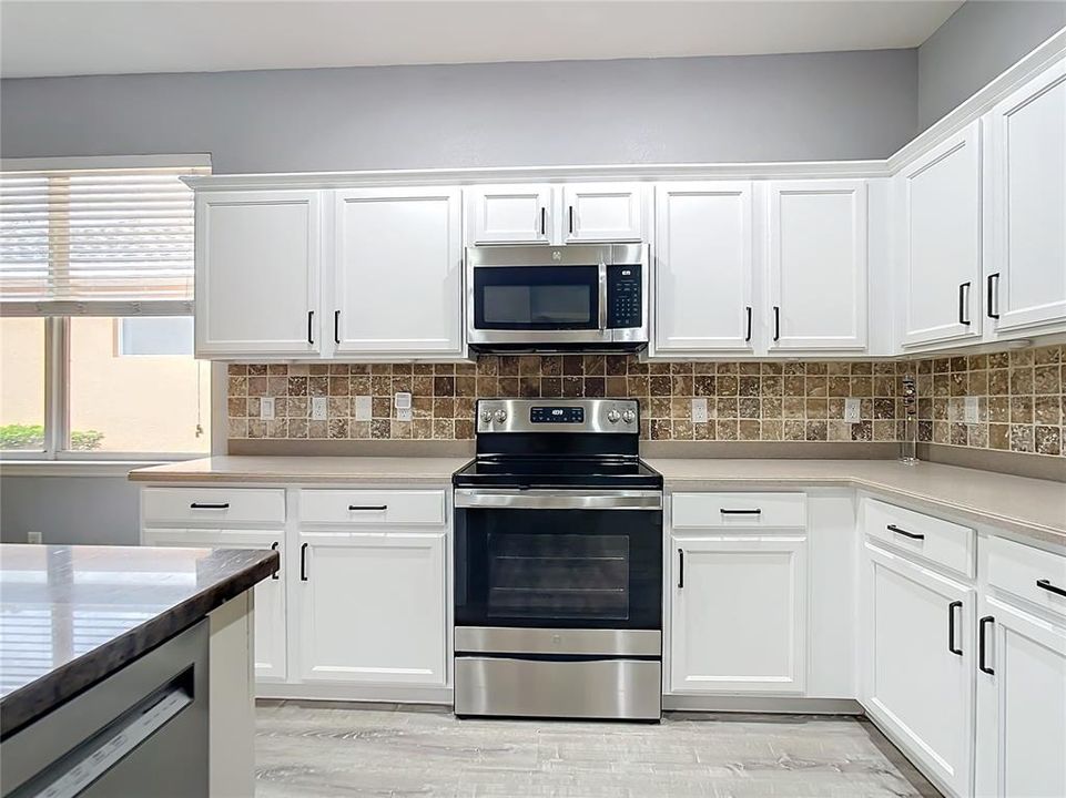 Kitchen with Corian countertops, tile backsplash.