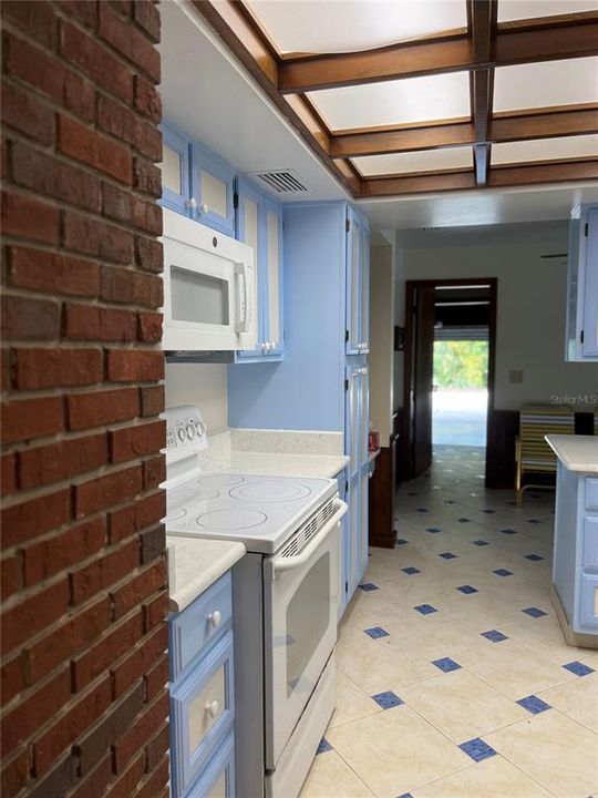 Hallway from kitchen/breakfast area leads past laundry room on right into the garage.