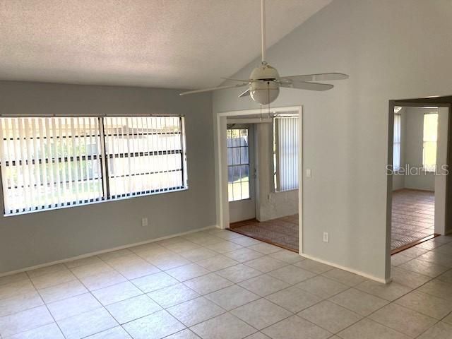 Entry leads into the living room, with vaulted ceilings and large window.  Open doorways into a bonus/office, and a Florida room.