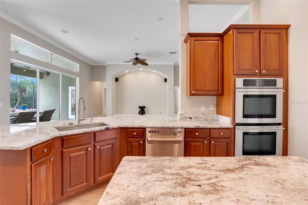 Kitchen features an island, new JennAir gas range, solid wood cabinets and granite countertops.