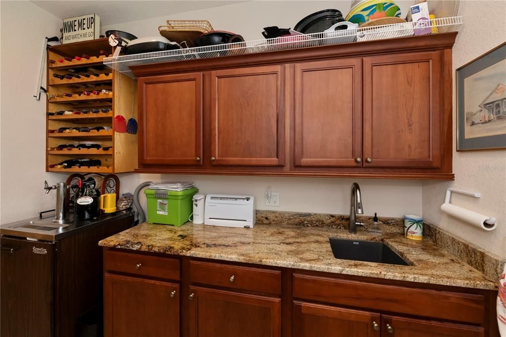 Inside laundry room has extra cabinetry storage plus tap