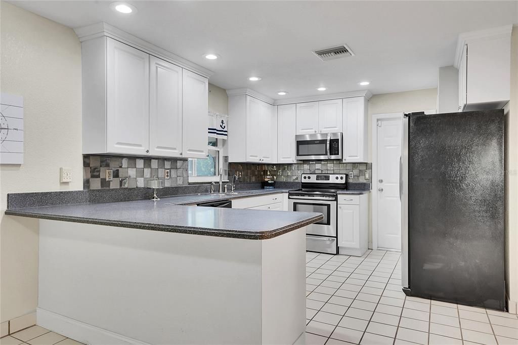 Updated Kitchen with Corian Countertops and Stainless Steel Appliances