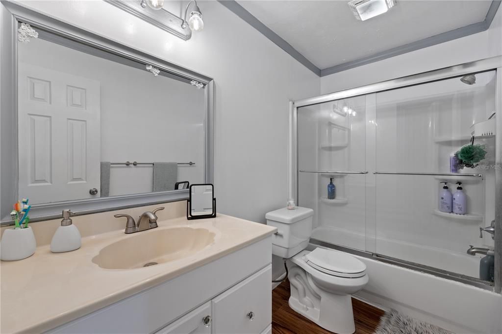 Guest bathroom with bathtub and large vanity.