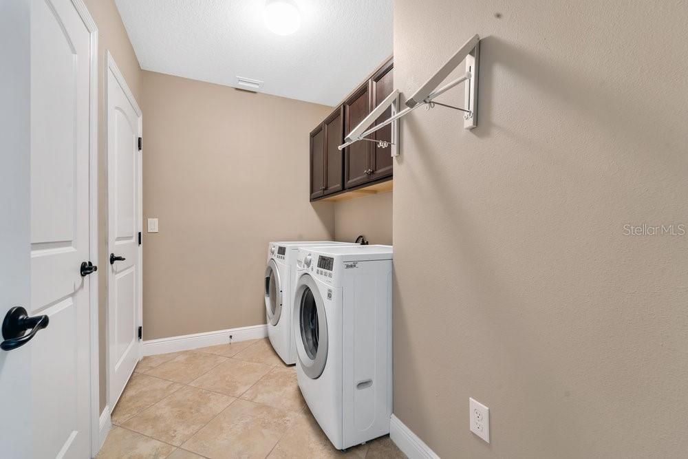 Downstairs laundry room with entrance to 2 car garage w ceiling storage