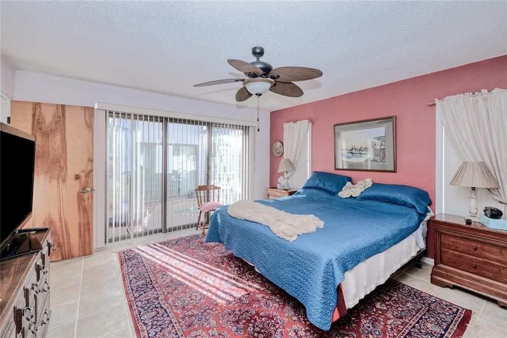 Primary Bedroom with slider doors to screened pool lanai space