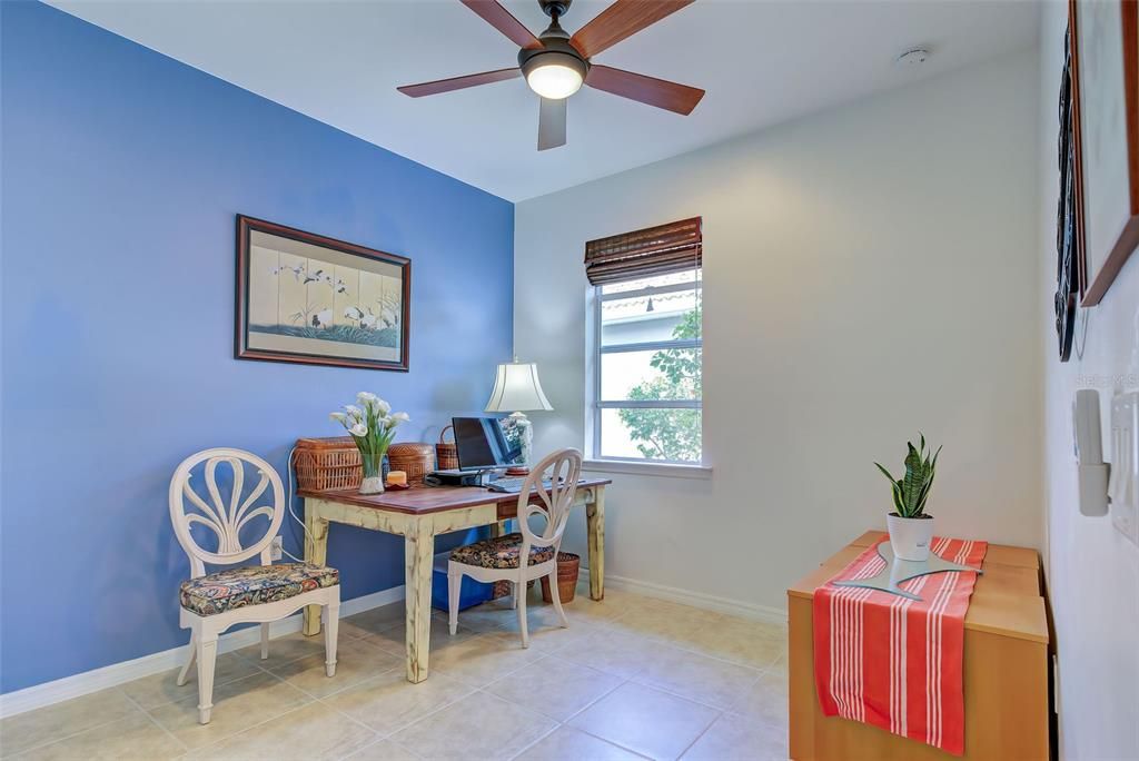 Guest room with neutral tile and ceiling fan