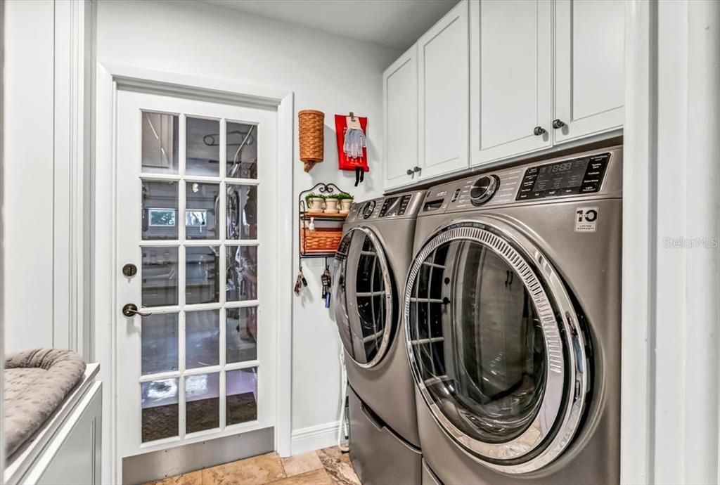 Laundry room with built ins and storage access under second floor landing