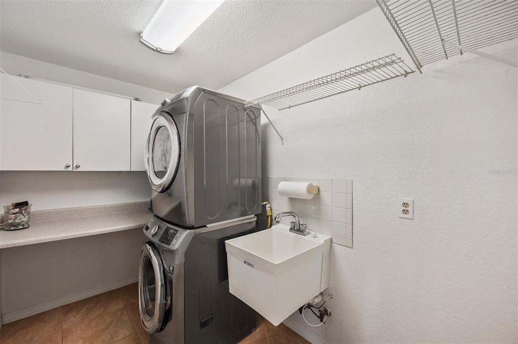 Spacious laundry room just outside the kitchen with plenty of room for storage. Natural gas Samsung washer & dryer, wash tub. Room for another refrigerator or freezer. Laundry room exits to the garage.