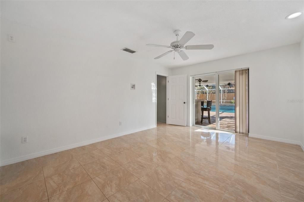 Master bedroom with pool view. Recessed electrical plugs for TV. Sliding glass doors to bar and pool.