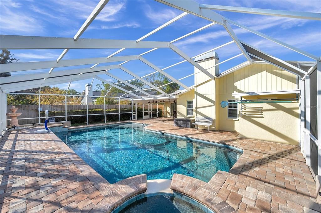 View of pool and hot tub. Natural gas heats hot tub and pool. Water fountain in corner to the upper left.Pavers recently sealed. Pool resurfaced 2022.