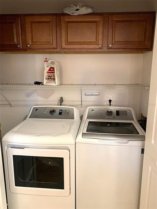 Washer-Dryer area in kitchen with cabs above.