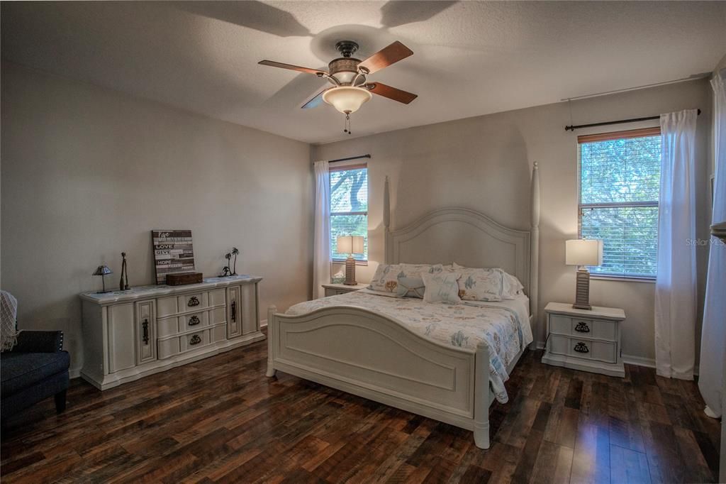 Retreat to the Primary Bedroom with rich laminate flooring.