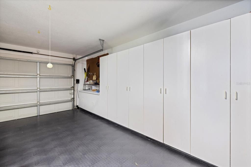 Garage with rubber tile flooring and lots of cabinets