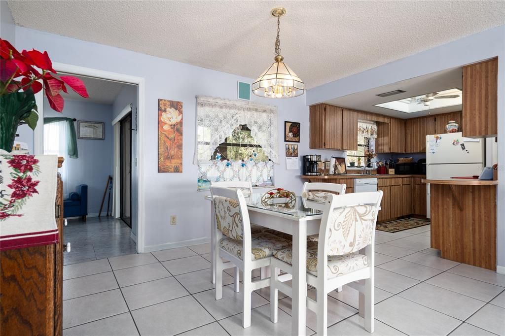 Dining area towards kitchen. Family room and rear porch entrance afar left.