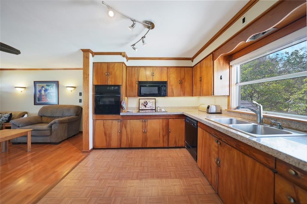 Loads of cabinets and countertops in the main home kitchen with an amazing view looking out over the pool