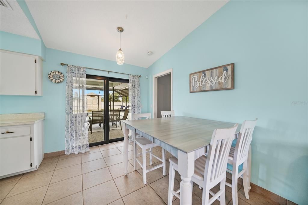 Kitchenette area. Door on right goes to primary bedroom. Sliding doors to pool and lanai. Kitchen to left.