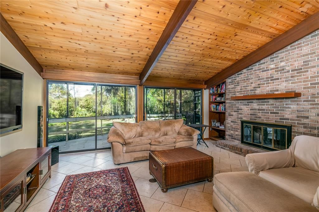 Family Room with screened porch beyond and conservation area beyond backyard.