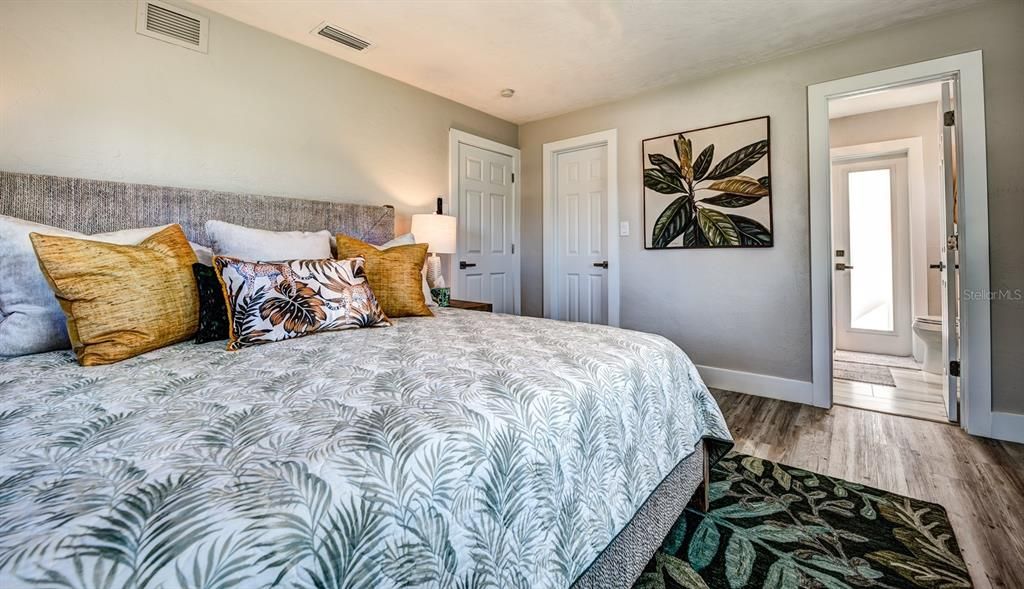 All interior doors, trim and hardware were upgraded throughout. The primary suite features a walk-in closet and the bath has an exterior door to the pool area.