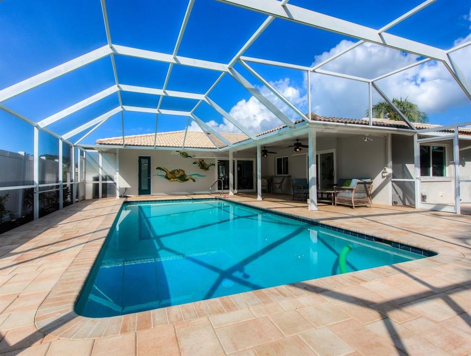 A stunning professionally painted mural graces the outdoor area. A door leads directly to the primary bathroom for convenience and fully pocketing sliders can be opened in the great room and dining room to allow the warm Florida breezes to flow through.