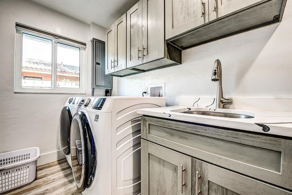 The huge laundry room has been enhanced with new luxury vinyl plank floors, storage cabinets, laundry sink with stone countertop and a front loading, energy efficient sanitizing washer & dryer. There is a large window for added light and the breaker box has been replaced.