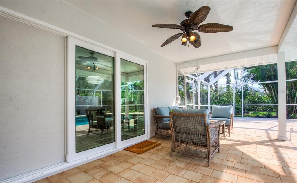 Fully pocketing hurricane resistant sliders open to the dining room and great room alike. A large pass through window with quartz bar top from the kitchen adds convenience during your family barbeques.