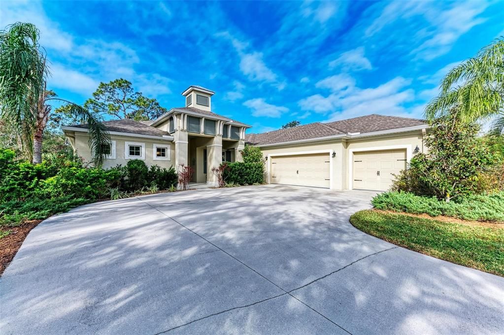 Exterior with large driveway, 3-car garage and front porch.