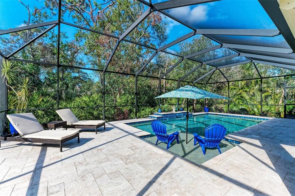 Large covered travertine lanai with tons of seating space.