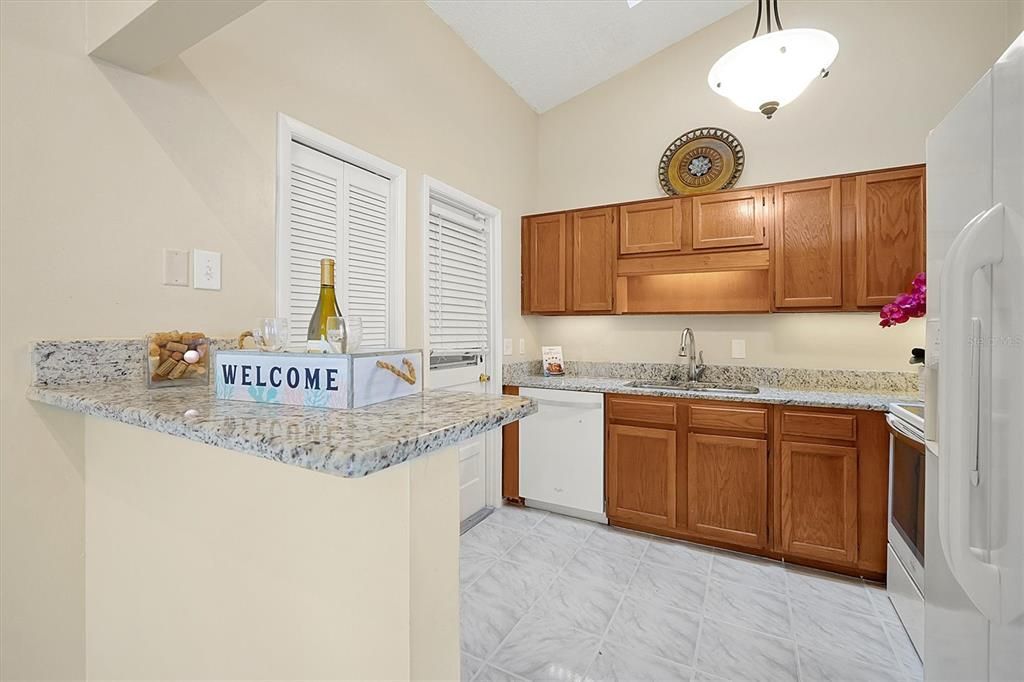 Kitchen with solid oak cabinets, deep set double sink and granite counters