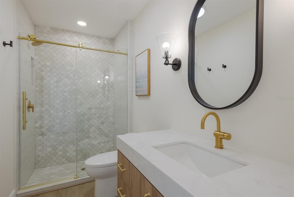 Bathroom #2 - West Villa - quartz counters, stellar lighting, porcelain tiled stand up shower