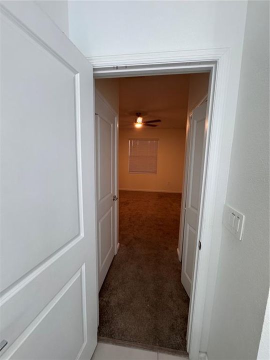 View from primary bathroom to primary bed.  Closets on either side.