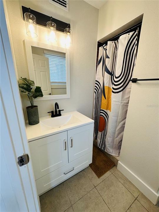 Bathroom with a walk-in shower in the smaller unit.