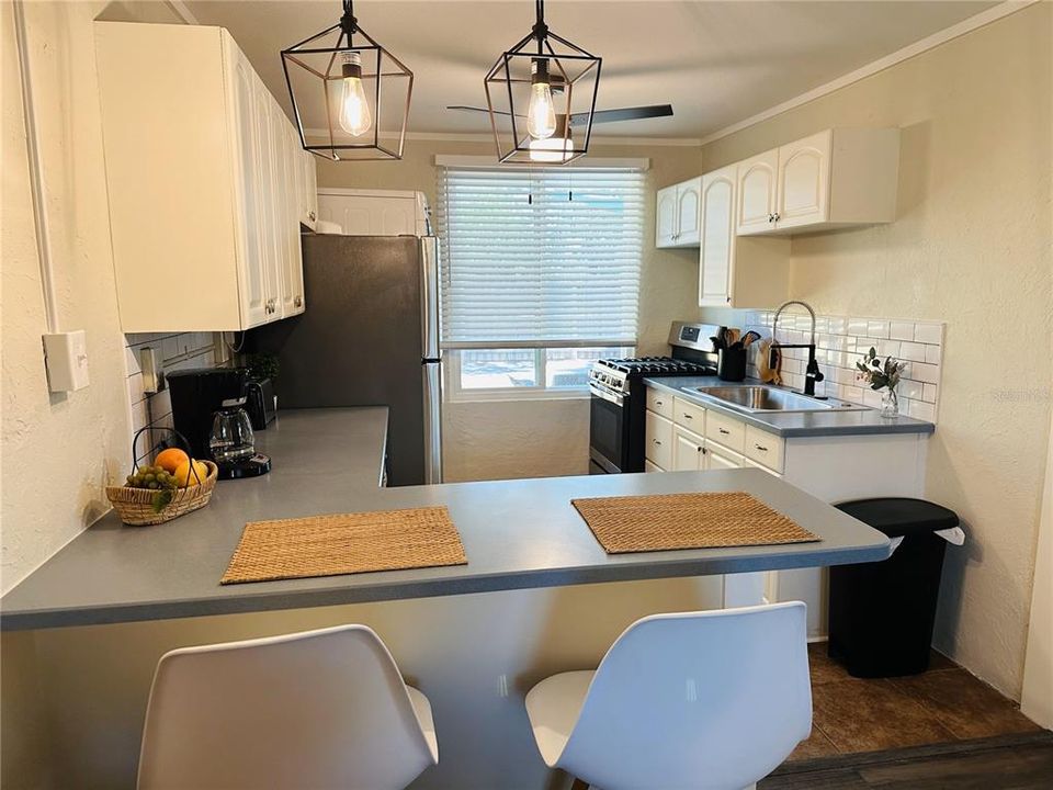 Smaller unit kitchen with contemporary light fixtures.