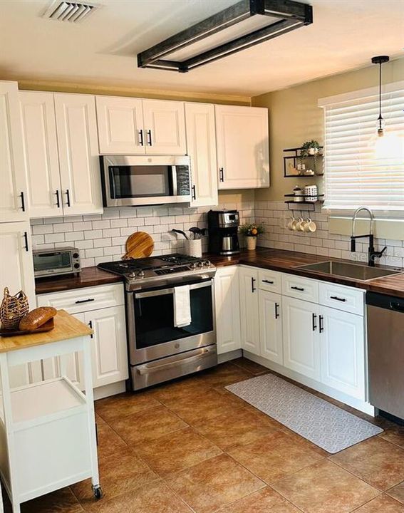 Kitchen in the bigger unit with stainless appliances and gas stove.