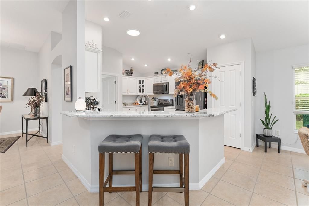 View of KITCHEN - Shows large peninsular BREAKFAST BAR with bar stool seating.